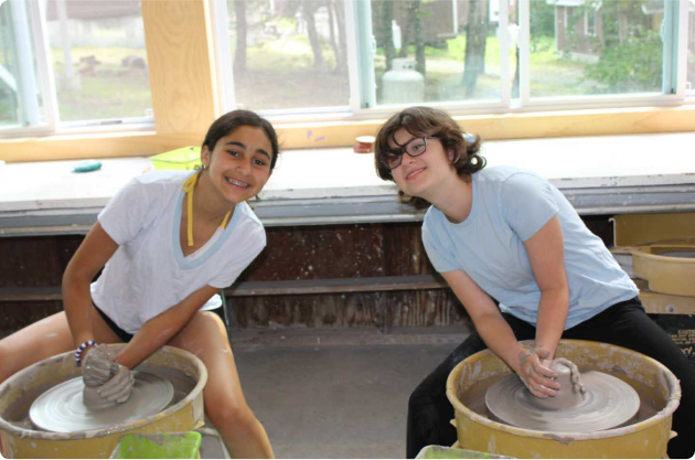 Two campers working on pottery.