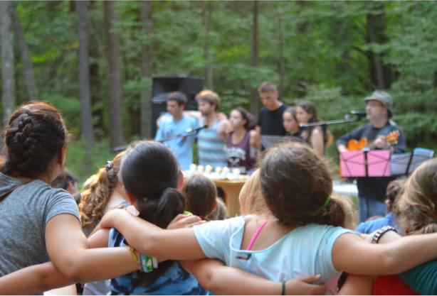 A group of campers watching a performance.