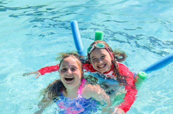 Two campers having fun in a swimming pool.