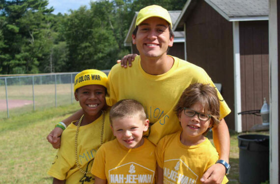 Three campers and a camp counselor smiling.