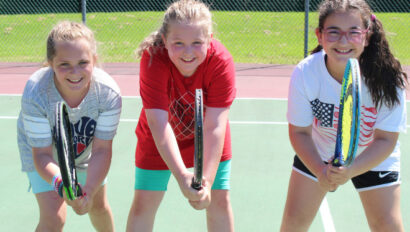 Three campers ready to play tennis.